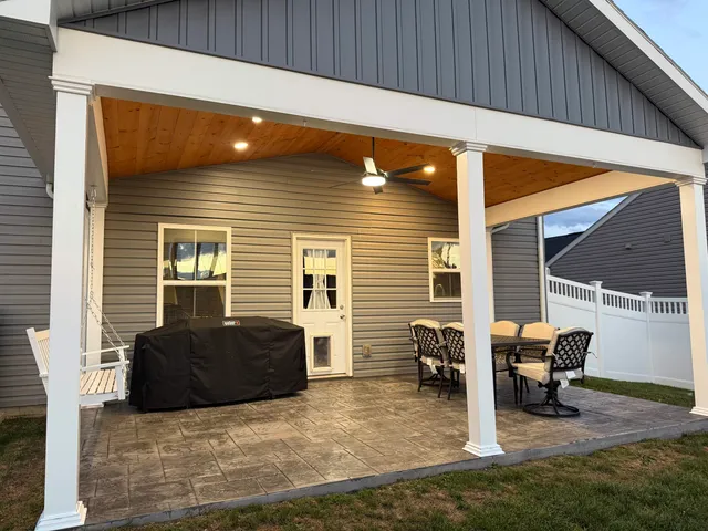 a kitchen with stainless steel appliances a dining table chairs stove refrigerator and cabinets