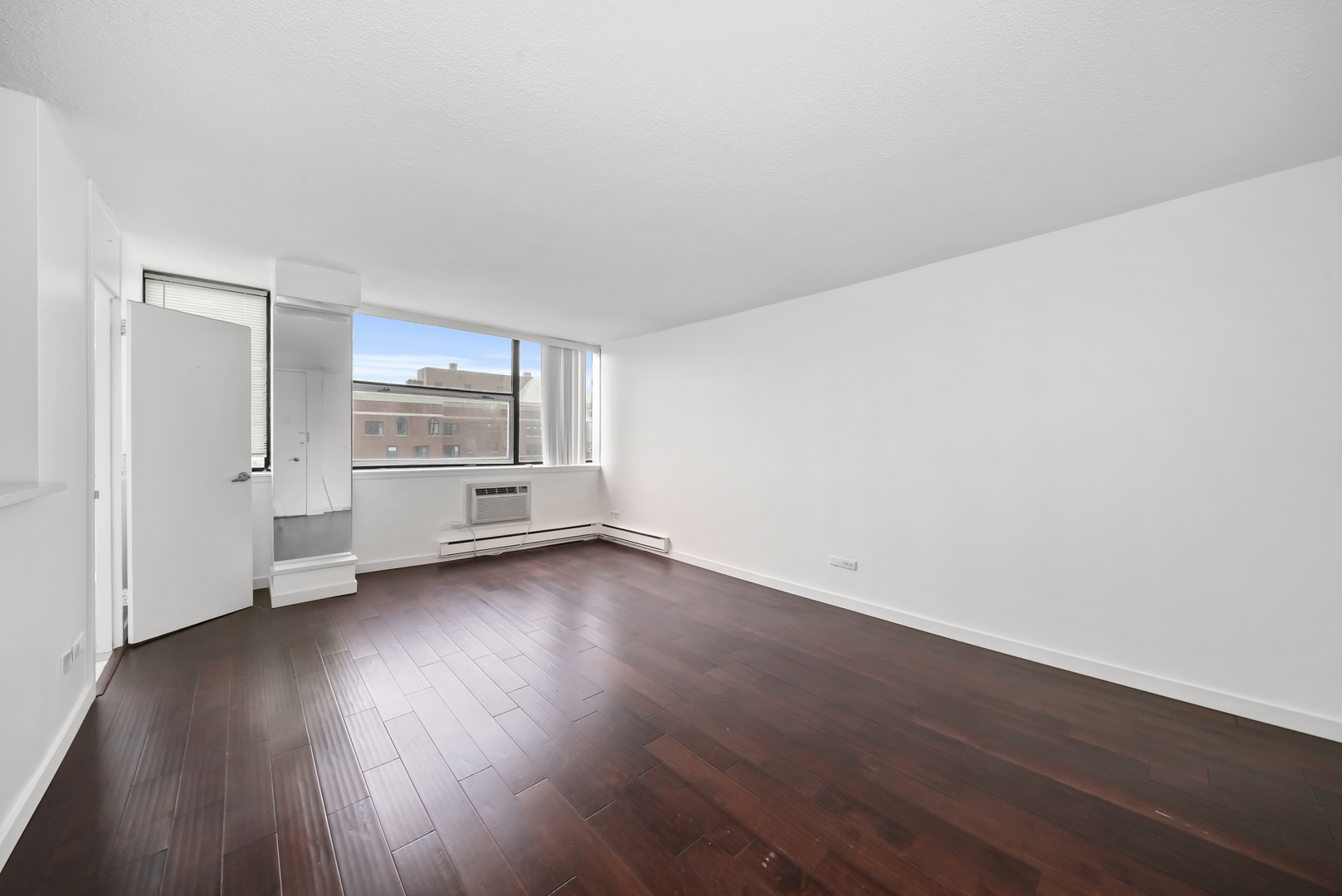 3110 North Sheridan Road, Unit 1207 Chicago, IL 60657 - Photo 11 of 32 an empty room with wooden floor closet and windows