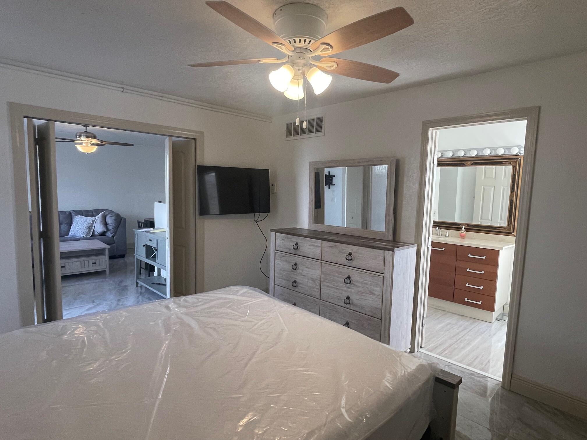 641 Executive Center Drive, Unit P105 West Palm Beach, FL 33401 - Photo 10 of 21 a bedroom with a bed and a dresser