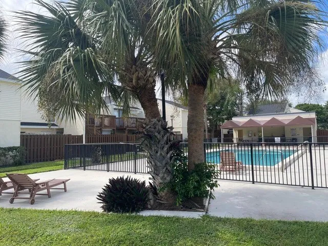 a view of a patio with table and chairs under an umbrella