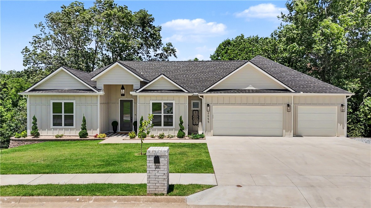 Contemporary ranch-style residence featuring horizontal siding, a dark shingle roof, and an attached two-car garage