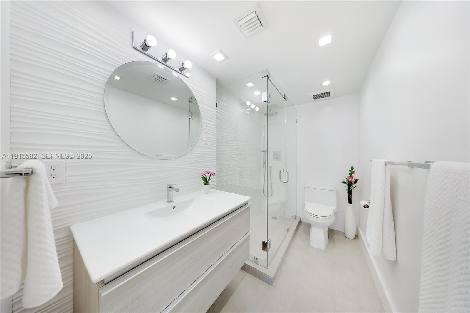 1450 Lincoln Road, Unit 1003 Miami Beach, FL 33139 - Photo 13 of 27 a bathroom with a sink a toilet and a mirror