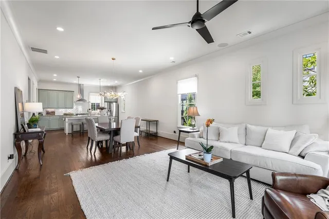 a living room with furniture a wooden floor and kitchen view