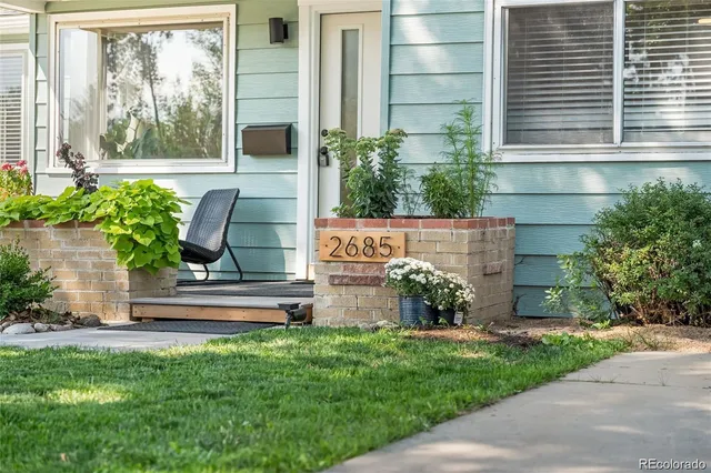 a view of house with backyard and a garden