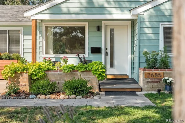 a front view of a house with potted plants