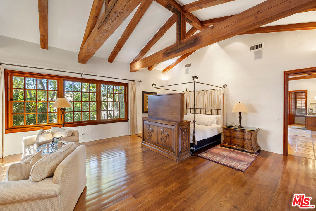 25127 Jim Bridger Road Hidden Hills, CA 91302 - Photo 23 of 50 a spacious bedroom with a bed and wooden floor