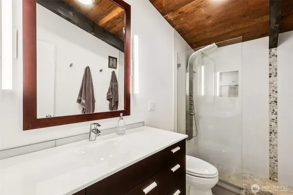 a bathroom with a sink vanity mirror and toilet