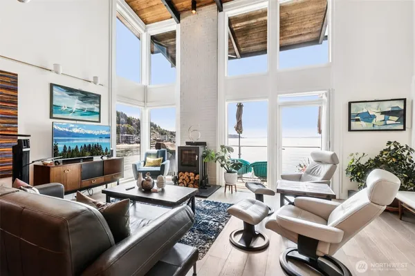 a living room with furniture kitchen view and large windows