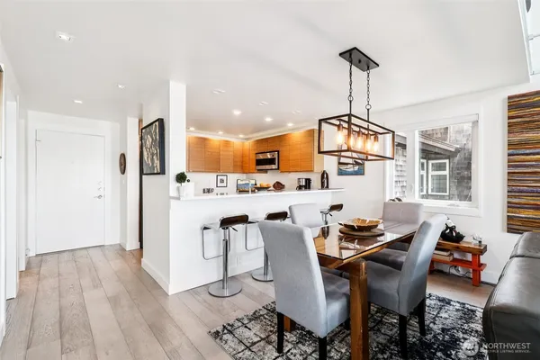 a kitchen with stainless steel appliances a dining table chairs stove and refrigerator
