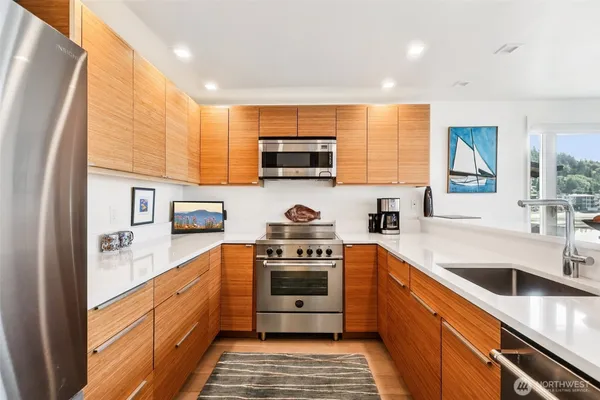 a kitchen with stainless steel appliances granite countertop a stove a sink and a refrigerator