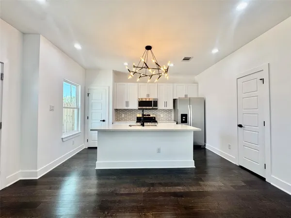 a view of kitchen with sink and refrigerator