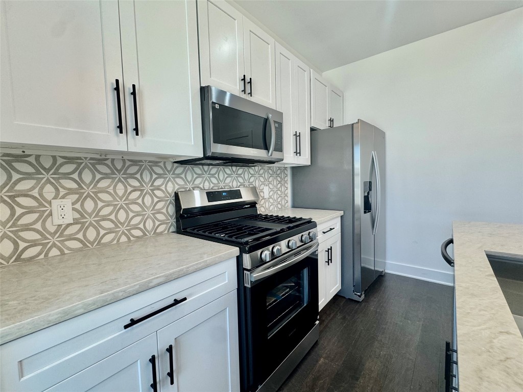 6928 Paris Street, Unit B Houston, TX 77021 - Photo 6 of 20 a kitchen with stainless steel appliances granite countertop a stove a refrigerator and a microwave