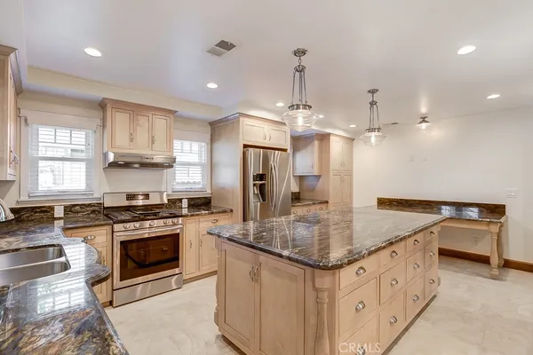 a kitchen with stainless steel appliances granite countertop a sink stove and refrigerator