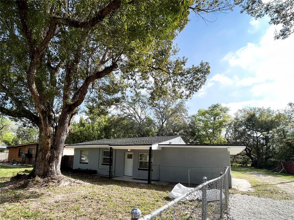 a view of house with yard and sitting area