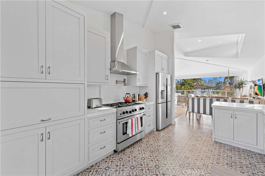 219 Emerald Bay Laguna Beach, CA 92651 - Photo 14 of 52 a kitchen with stainless steel appliances white cabinets and wooden floors