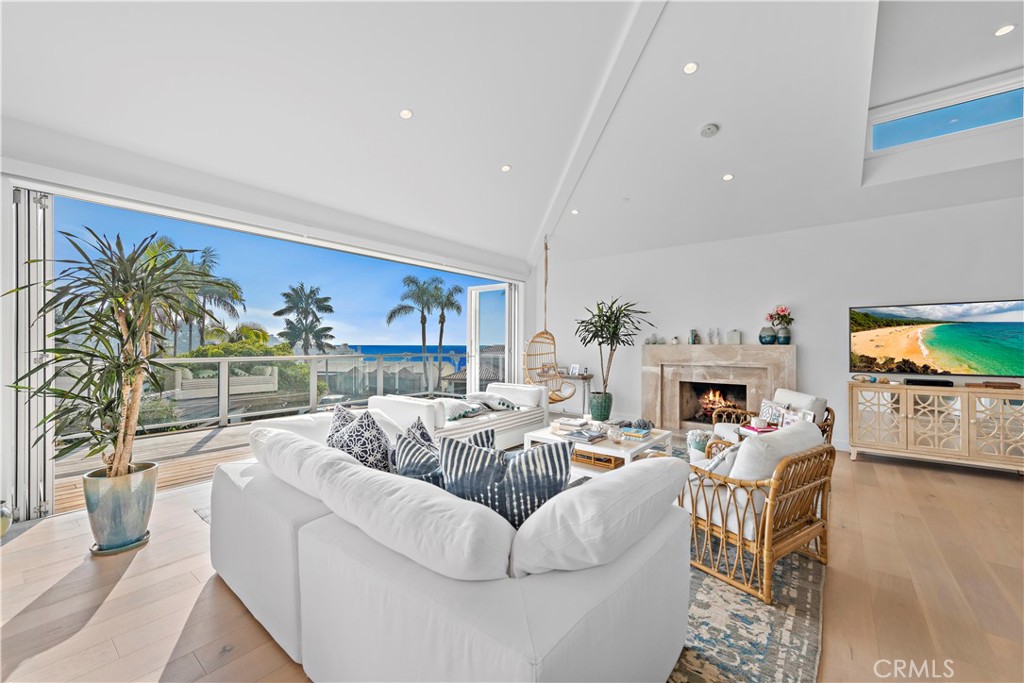 219 Emerald Bay Laguna Beach, CA 92651 - Photo 3 of 52 a living room with furniture a fireplace and a flat screen tv