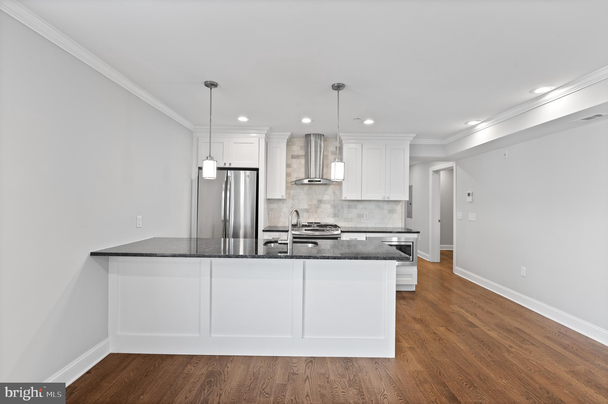 988 North Marshall Street, Unit 2R Philadelphia, PA 19123 - Photo 11 of 29 a kitchen with stainless steel appliances granite countertop a sink a stove a refrigerator and white cabinets