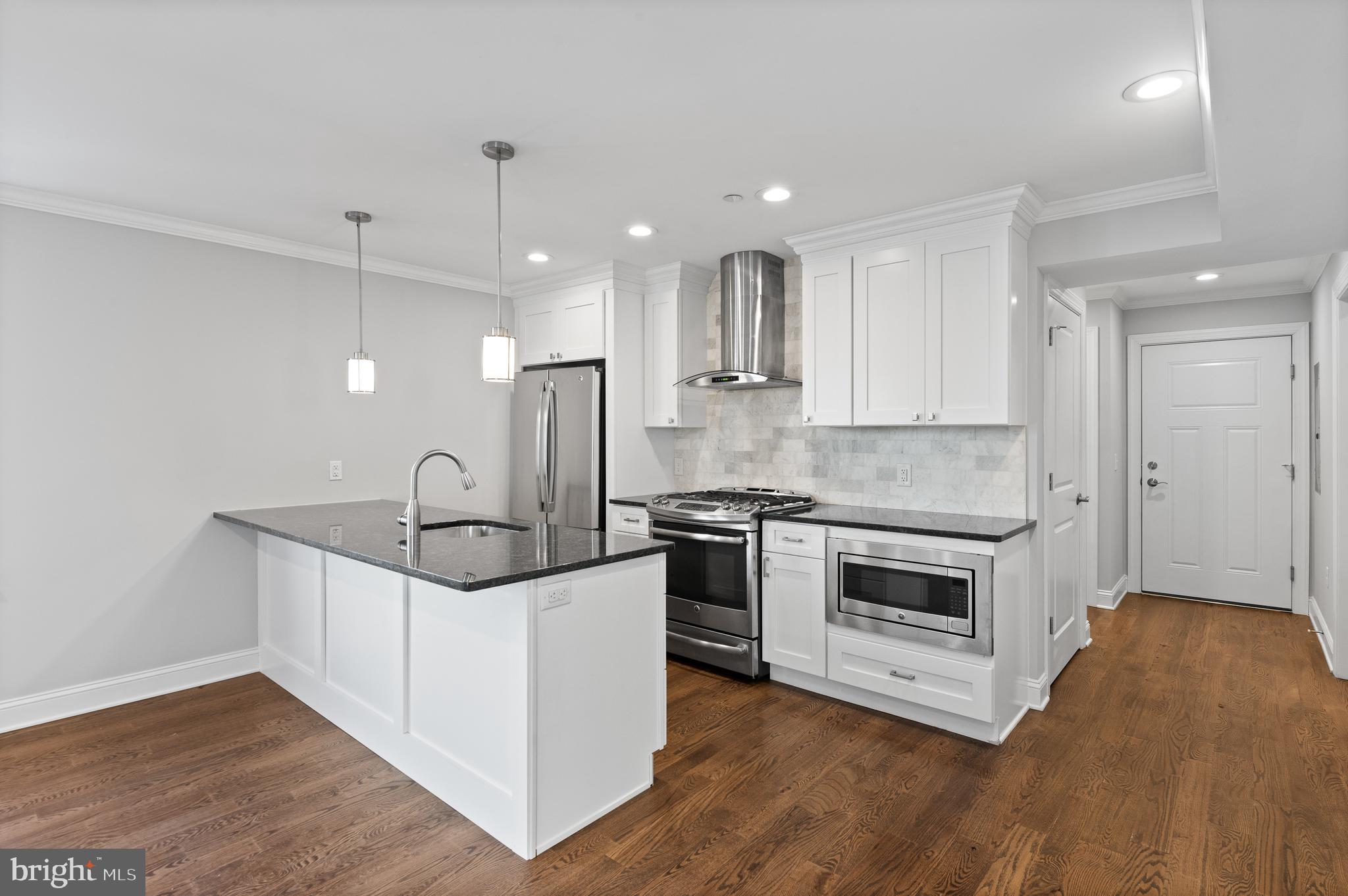 988 North Marshall Street, Unit 2R Philadelphia, PA 19123 - Photo 6 of 29 a kitchen with stainless steel appliances granite countertop a sink stove and a refrigerator