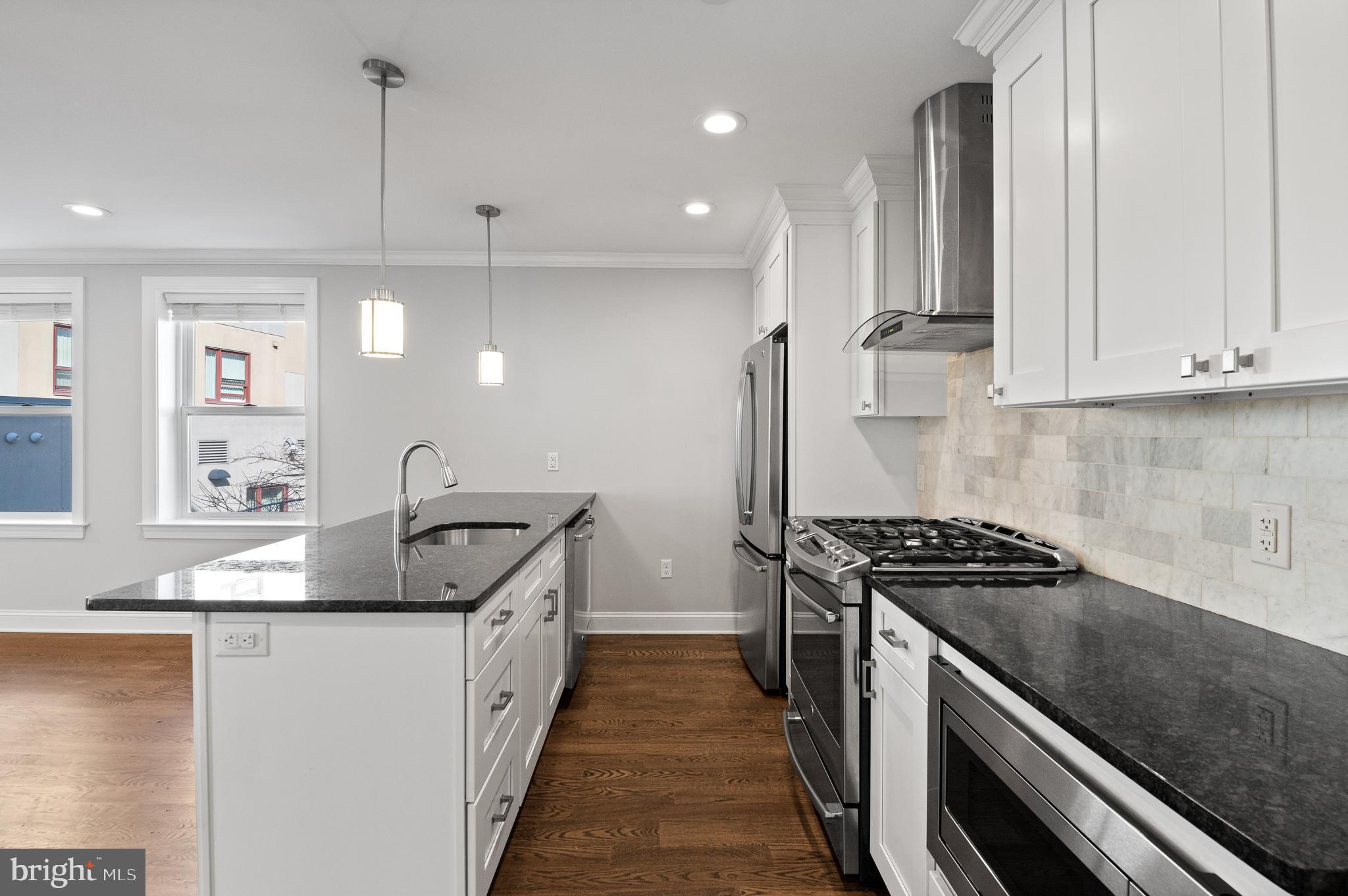 988 North Marshall Street, Unit 2R Philadelphia, PA 19123 - Photo 9 of 29 a kitchen with stainless steel appliances granite countertop a sink a stove and a wooden floors