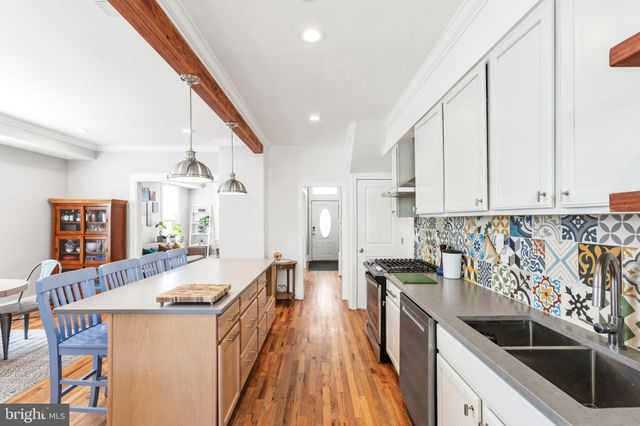 a kitchen with granite countertop a sink a counter top space stainless steel appliances and cabinets