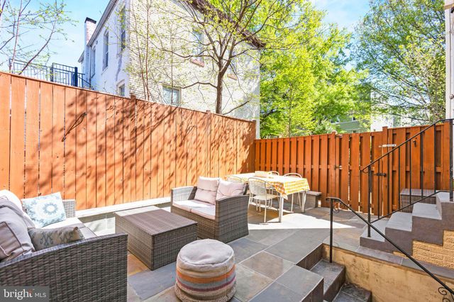 a view of a chairs and table in the back yard of a house
