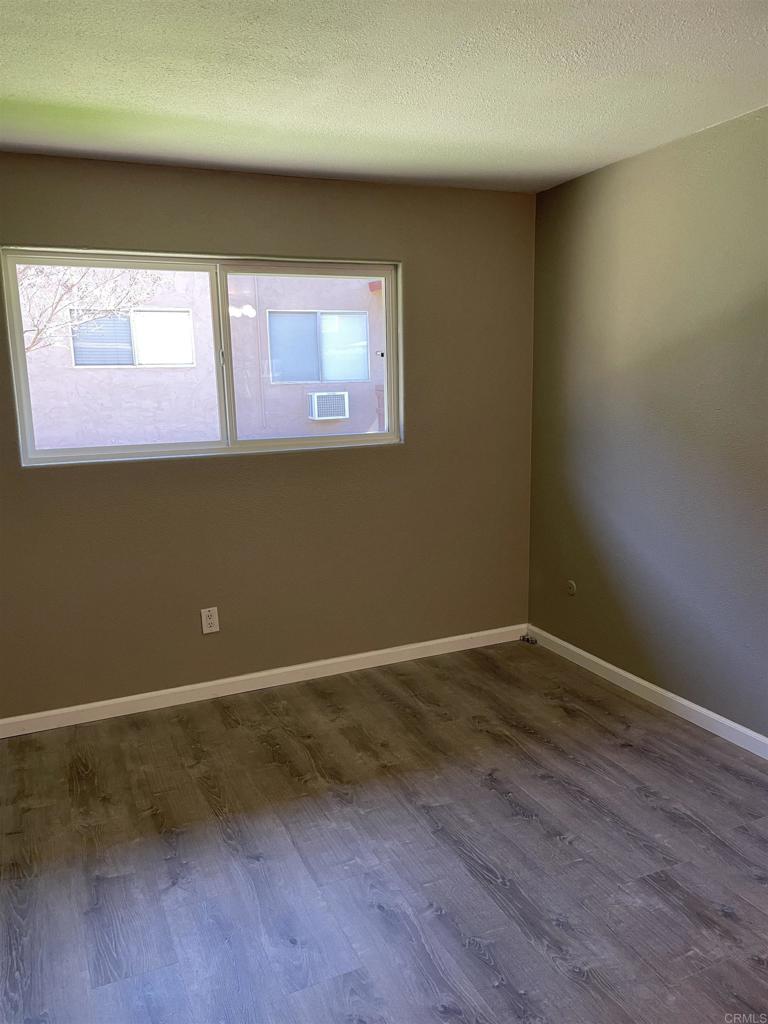 9717 Winter Gardens Boulevard, Unit 194 Lakeside, CA 92040 - Photo 11 of 19 a view of an empty room with wooden floor and a window