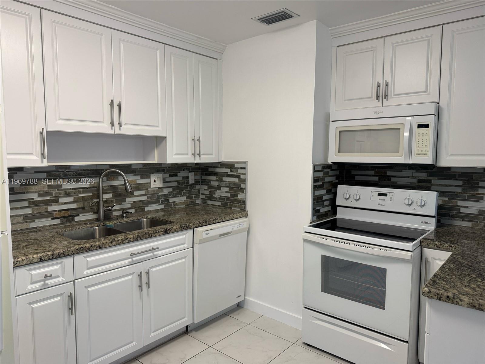 15332 Southwest 80th Lane, Unit 15332 Miami, FL 33193 - Photo 4 of 16 a kitchen with white cabinets and appliances