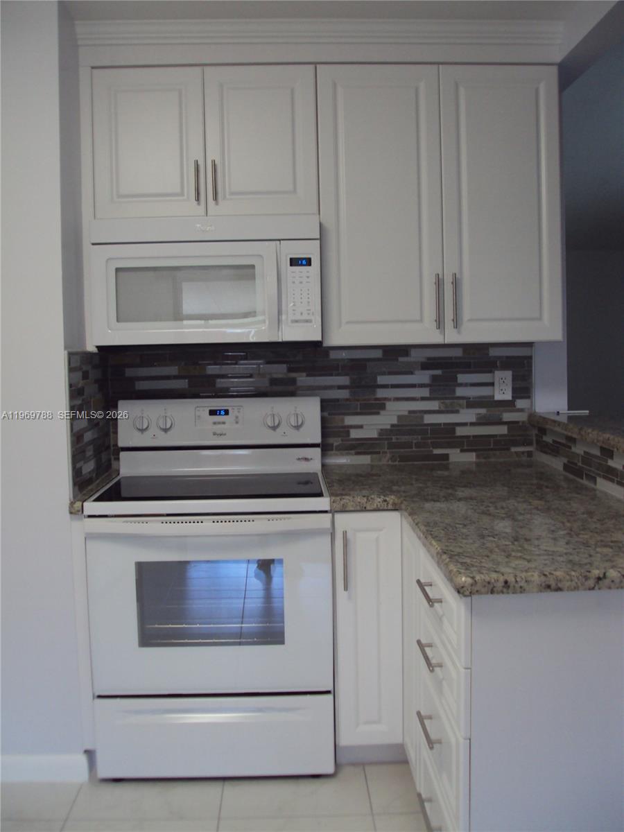 15332 Southwest 80th Lane, Unit 15332 Miami, FL 33193 - Photo 5 of 16 a stove top oven sitting inside of a kitchen