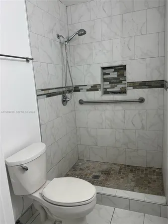 a bathroom with a toilet and a shower