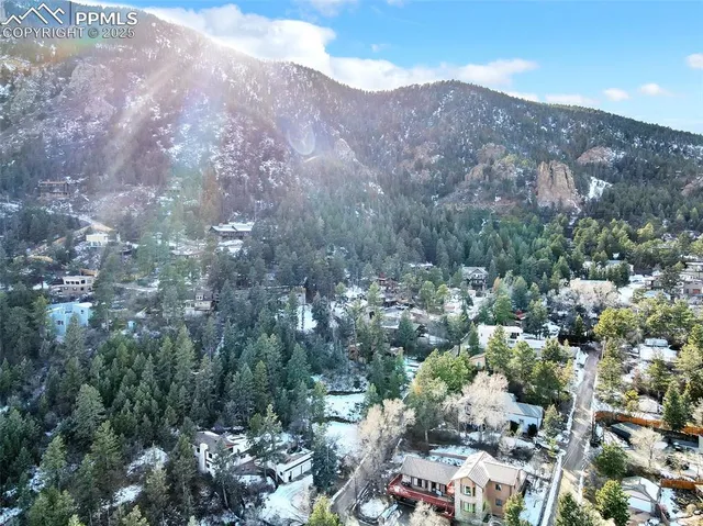 an aerial view of a houses with a lush green hillside
