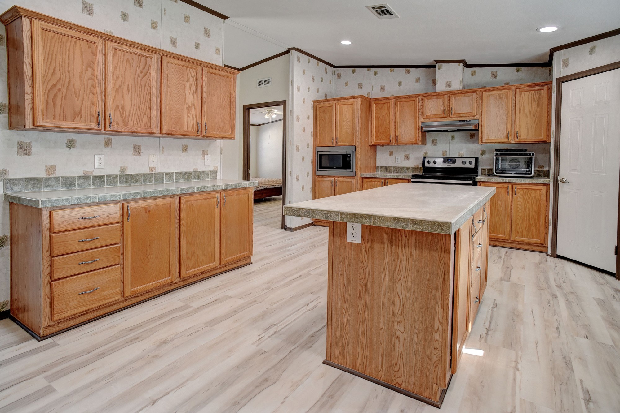 552 South Old Potato Road Paige, TX 78659 - Photo 11 of 40 a kitchen with stainless steel appliances granite countertop a refrigerator a stove top oven a sink and dishwasher with wooden floor
