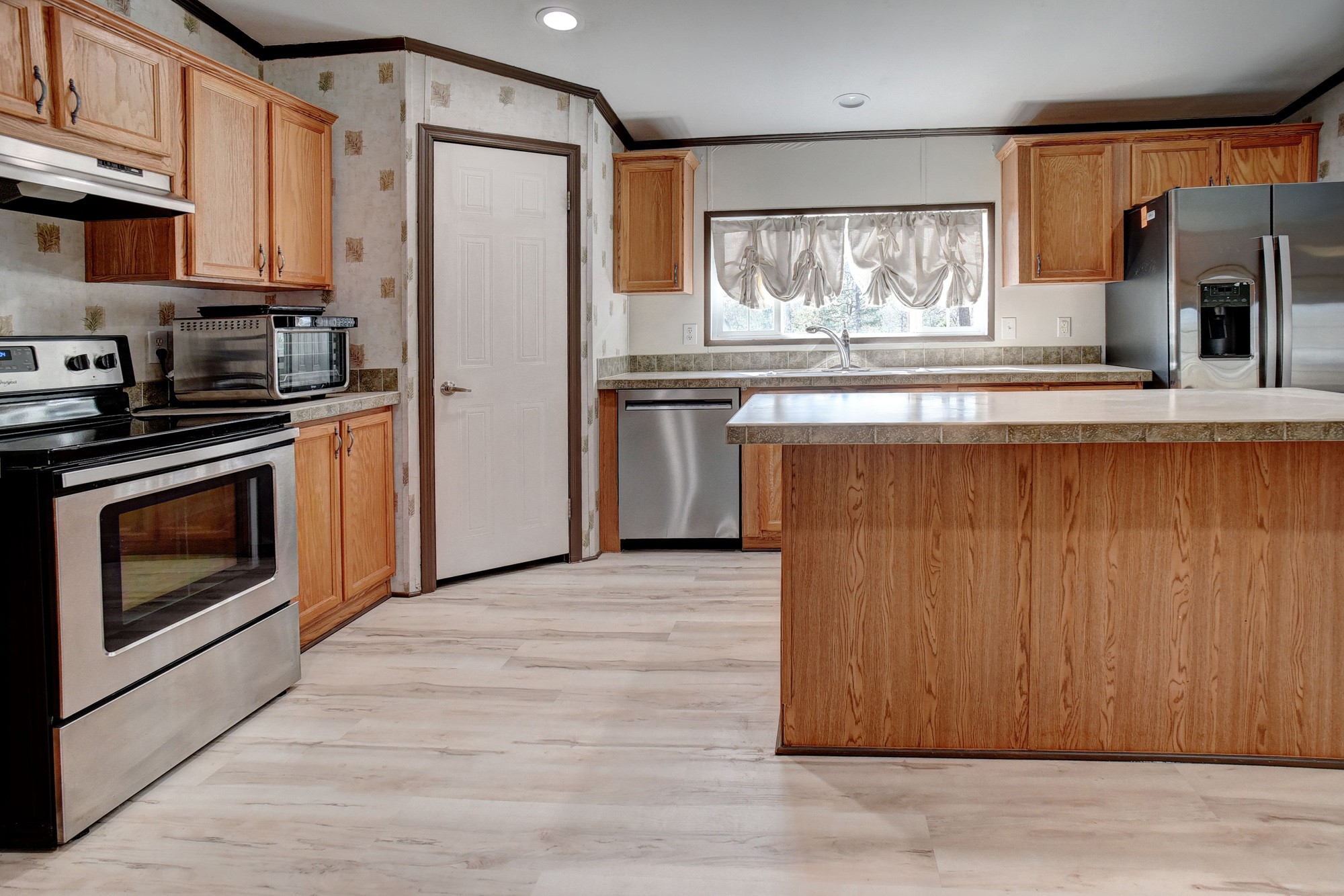 552 South Old Potato Road Paige, TX 78659 - Photo 12 of 40 a kitchen with stainless steel appliances granite countertop a refrigerator sink and stove