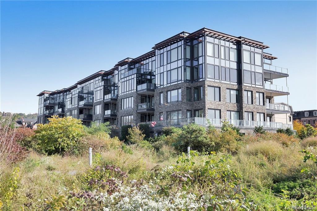 18 Rivers Edge Drive, Unit 305 Tarrytown, NY 10591 - Photo 23 of 34 a tall building sitting in the middle of a yard
