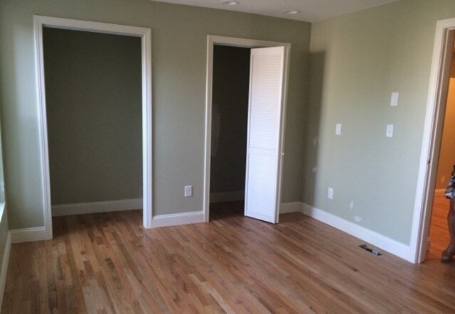 35 Forbes Street, Unit 1 Boston, MA 02130 - Photo 3 of 6 an empty room with wooden floor and closet