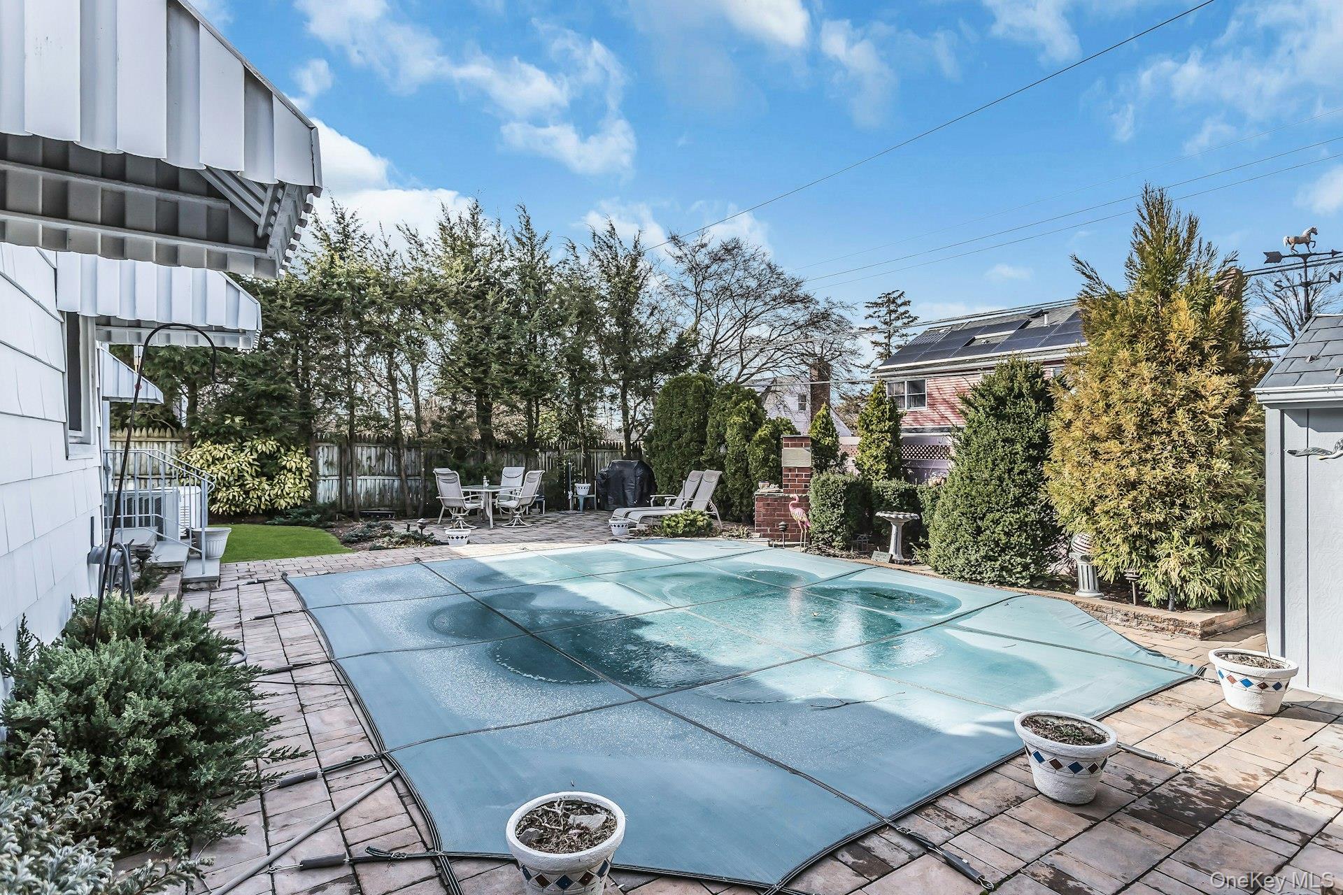 5 Sherwood Road Glen Cove, NY 11542 - Photo 22 of 26 View of pool with patio surround and a covered pool