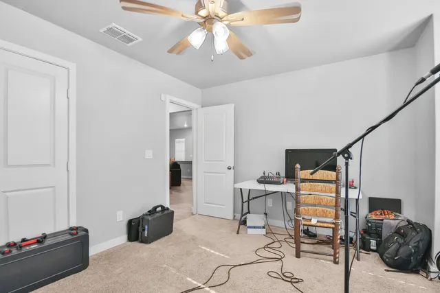 a bedroom with furniture and a chandelier fan