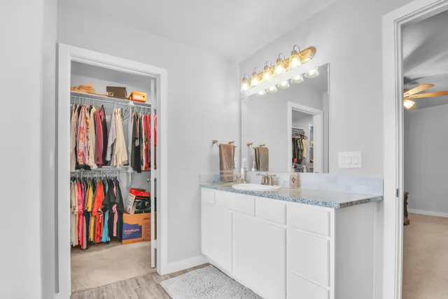 a en suite bathroom with a granite countertop sink and a mirror