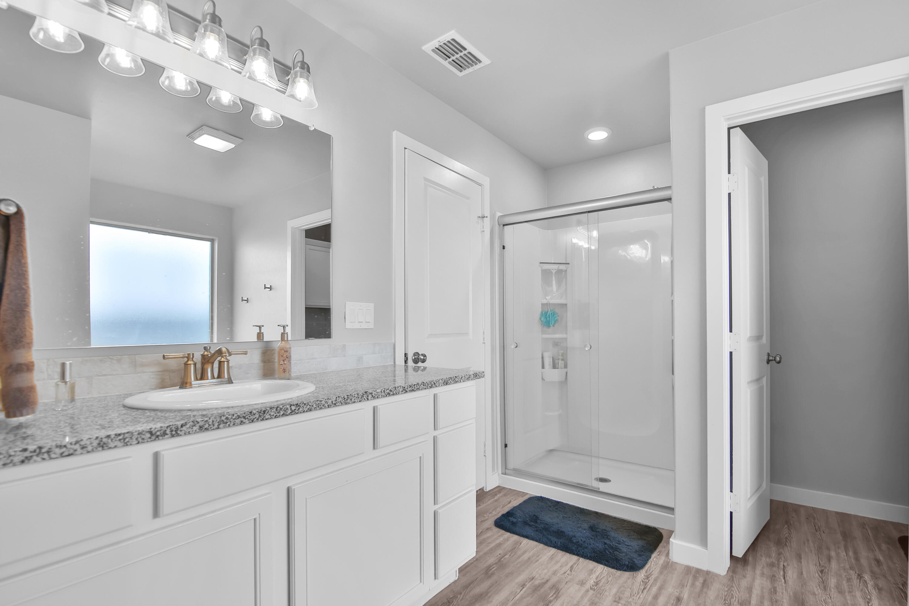 1716 133rd Street Lubbock, TX 79423 - Photo 33 of 37 a bathroom with a granite countertop sink a large mirror and shower