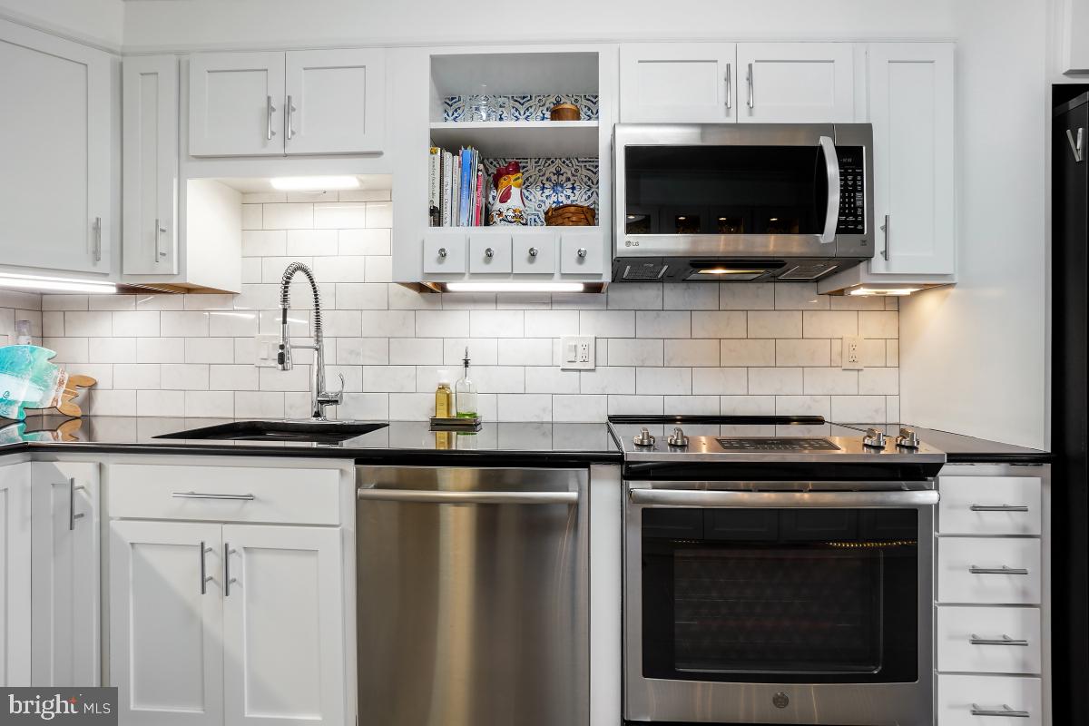 5902 Mt Eagle Drive, Unit 1615 Alexandria, VA 22303 - Photo 24 of 48 a kitchen with stainless steel appliances a stove microwave and cabinets