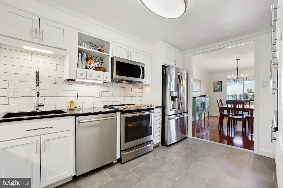 5902 Mt Eagle Drive, Unit 1615 Alexandria, VA 22303 - Photo 25 of 48 a kitchen with stainless steel appliances granite countertop a stove top oven a sink dishwasher with a dining table and chairs
