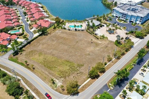an aerial view of ocean and residential houses with outdoor space