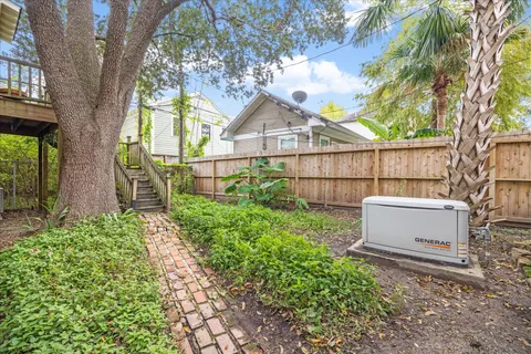 a view of a backyard with a tree and wooden fence