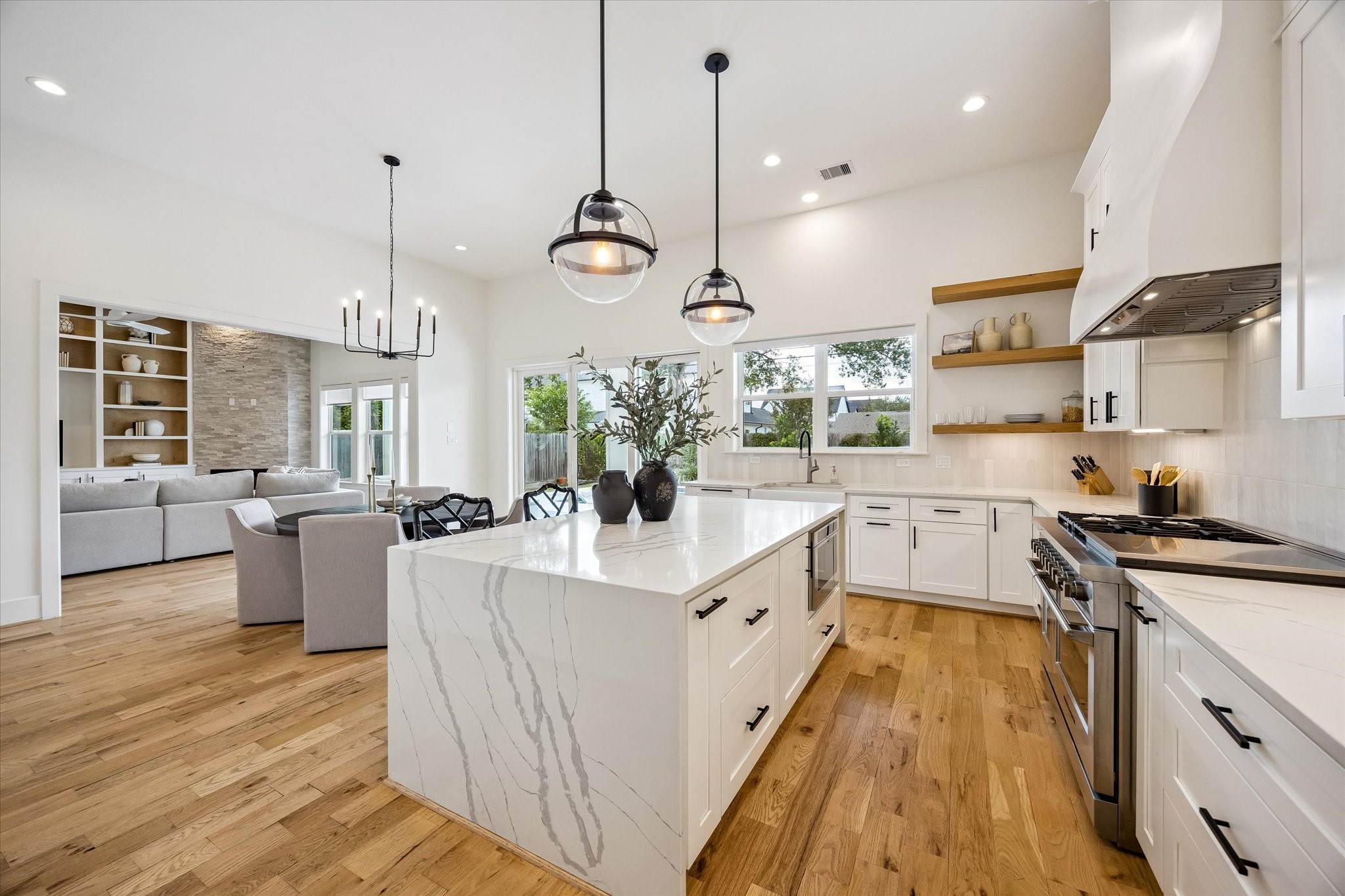 1729 Chippendale Road Houston, TX 77018 - Photo 4 of 45 A waterfall quartz island with bar seating anchors the chef’s kitchen, complemented by custom cabinetry and sophisticated finishes.