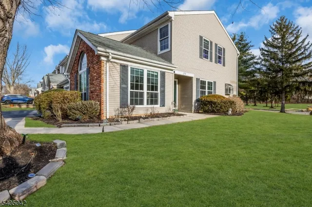 a front view of a house with a yard and trees