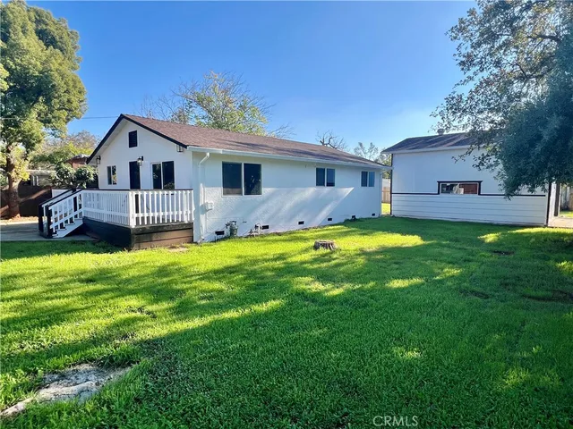 a front view of house with yard and trees in the background