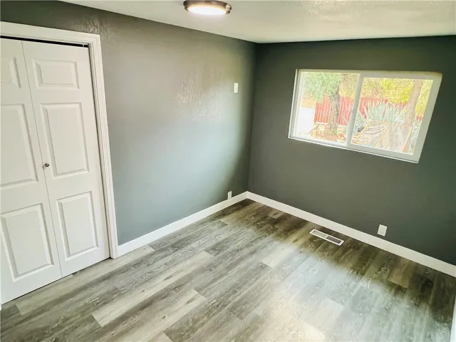 a view of a room with wooden floor and a window
