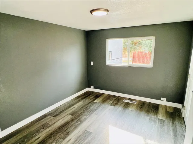 a view of a room with wooden floor and wall painting