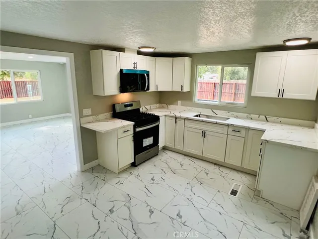 a kitchen with a sink stove top oven and cabinets