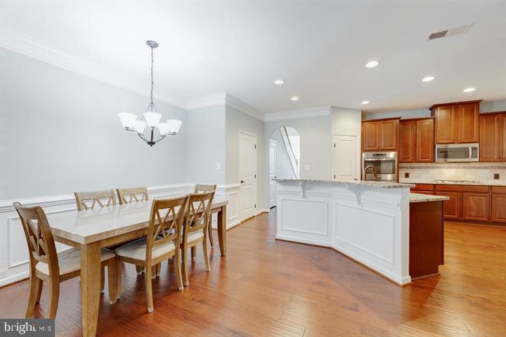 24876 Helms Terrace Aldie, VA 20105 - Photo 10 of 45 a kitchen with a table chairs and white cabinets