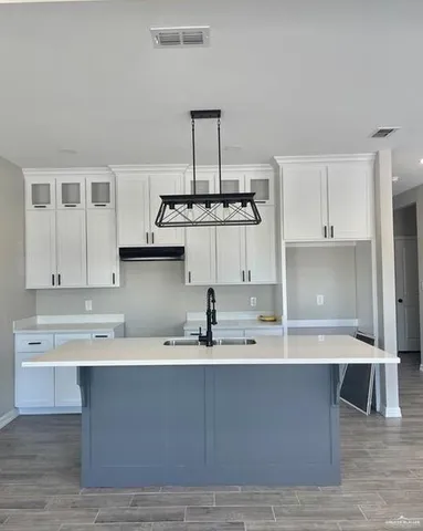 a kitchen with kitchen island a sink stainless steel appliances and cabinets